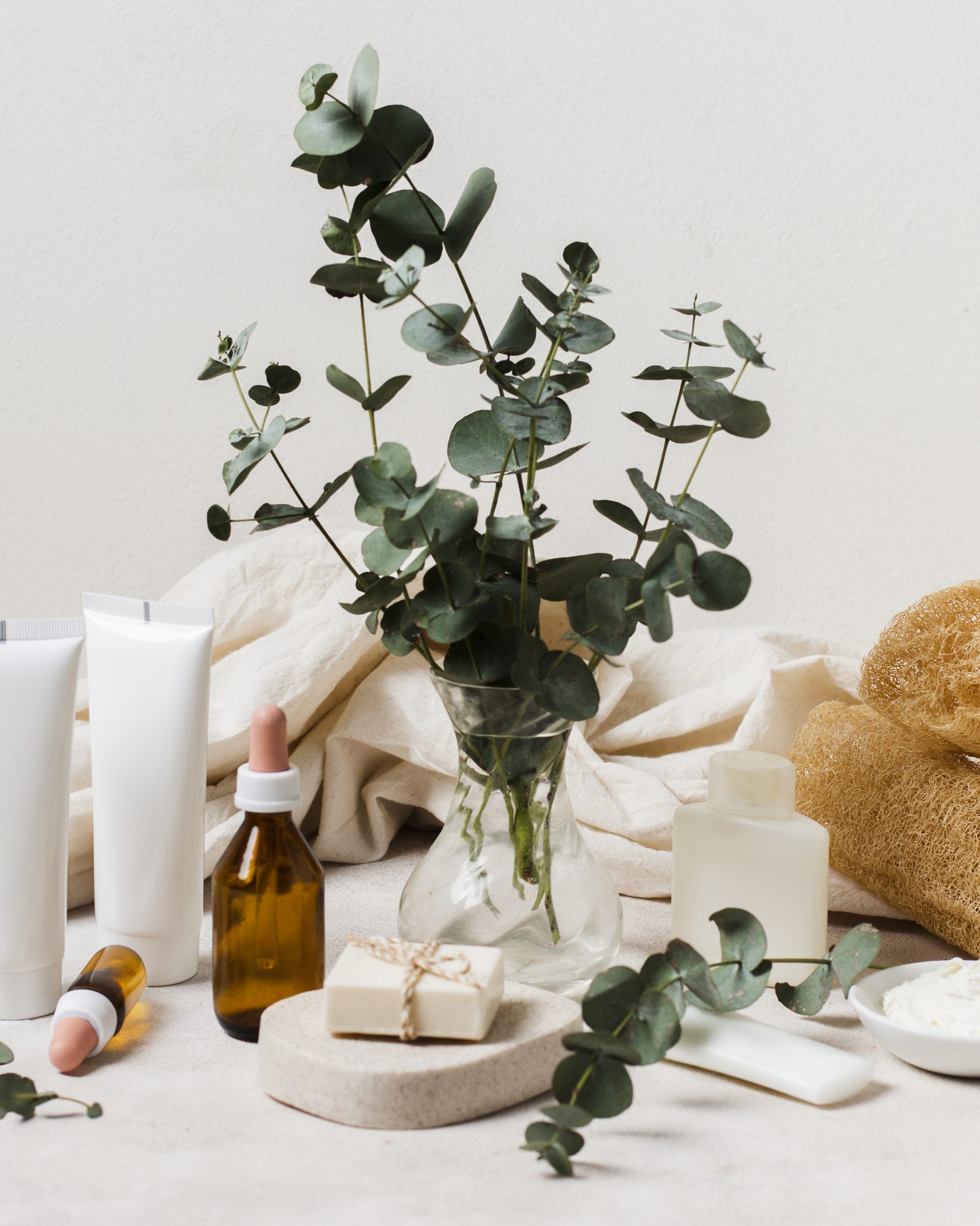 Unlabelled natural skincare products styled with eucalyptus